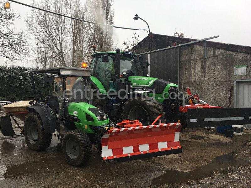 Winterdienst met tractor met  sneeuwschuif en zoutstrooier
